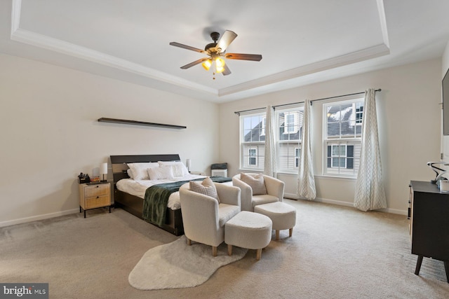 bedroom featuring ceiling fan, light colored carpet, and a tray ceiling