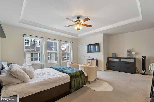 bedroom featuring ceiling fan, a raised ceiling, ornamental molding, and carpet flooring