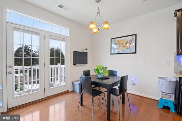 dining space with a chandelier and wood-type flooring