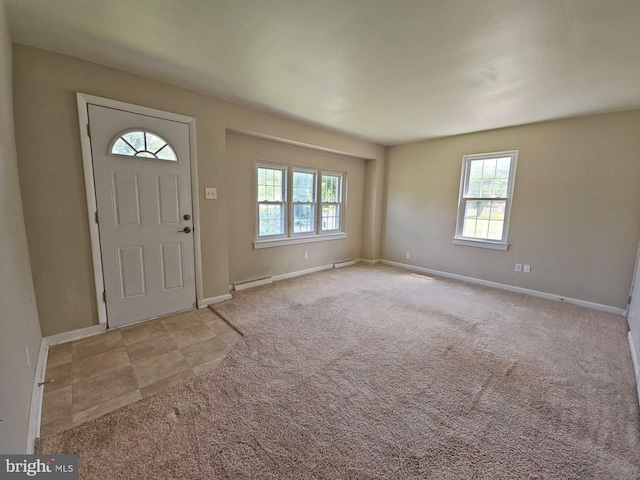 entryway with light colored carpet and a wealth of natural light