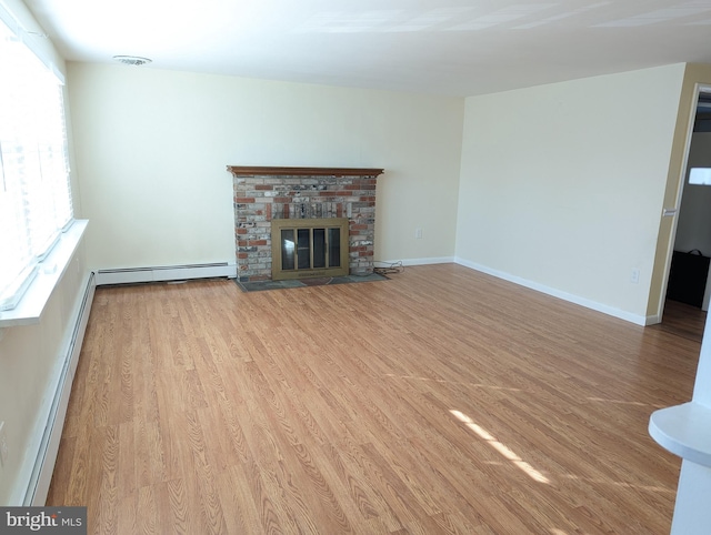 unfurnished living room with a fireplace, a baseboard radiator, and light hardwood / wood-style flooring