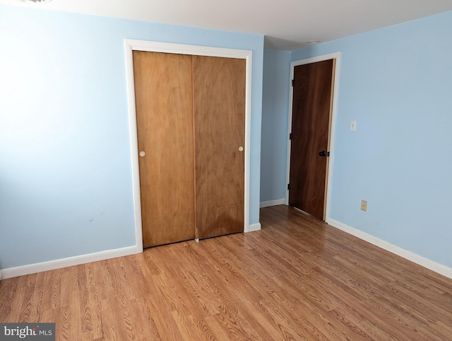 unfurnished bedroom with light hardwood / wood-style floors and a closet