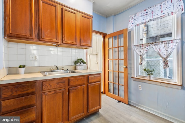 kitchen with sink, light hardwood / wood-style floors, and tasteful backsplash