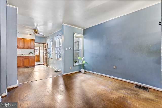 unfurnished living room with ceiling fan, hardwood / wood-style floors, and sink