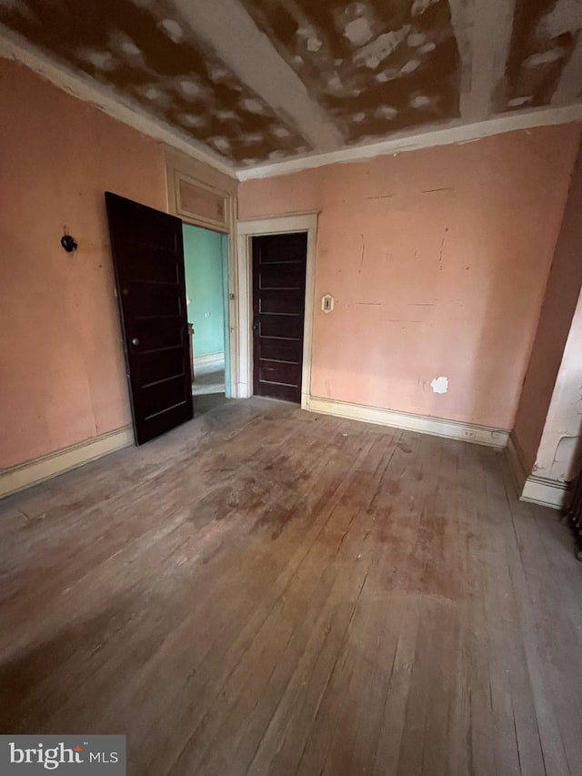 spare room featuring crown molding and hardwood / wood-style floors