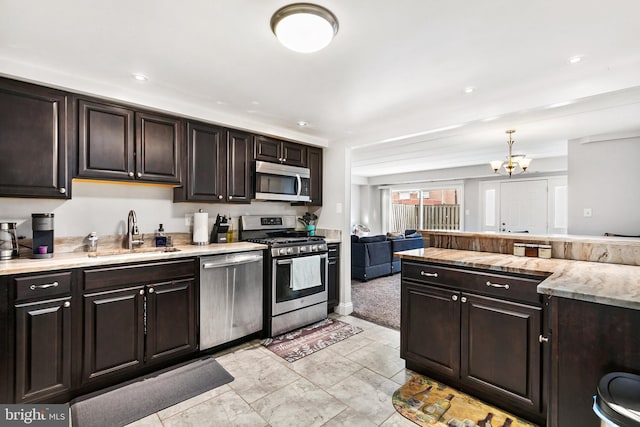 kitchen with sink, light tile patterned floors, appliances with stainless steel finishes, dark brown cabinetry, and a chandelier