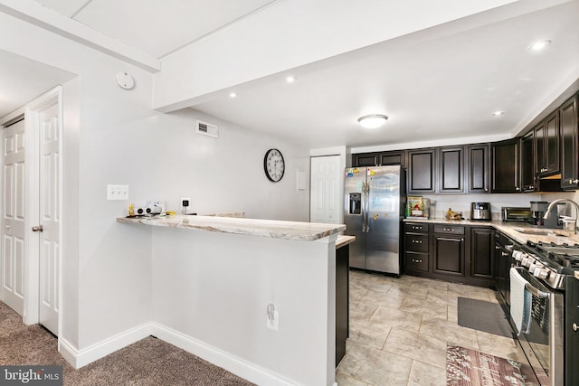 kitchen featuring stainless steel appliances, kitchen peninsula, sink, and dark brown cabinets