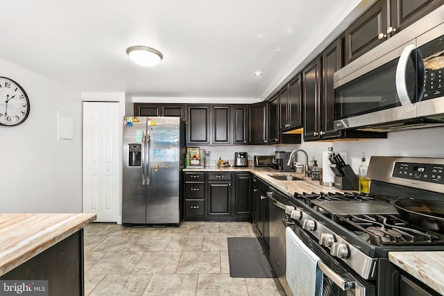 kitchen featuring dark brown cabinetry, sink, and stainless steel appliances