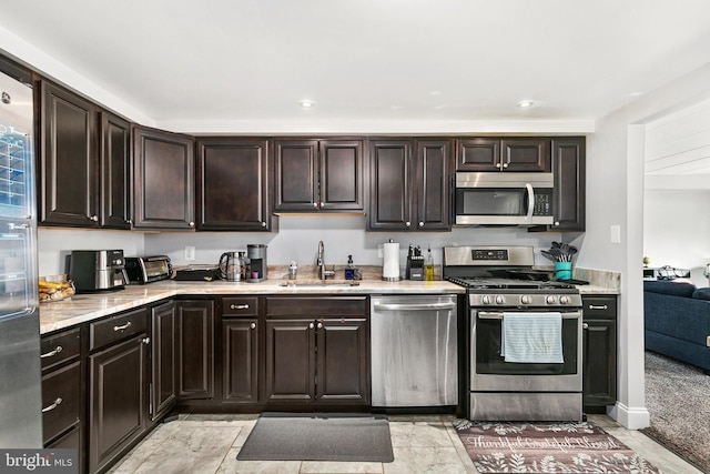 kitchen featuring appliances with stainless steel finishes, sink, and dark brown cabinets