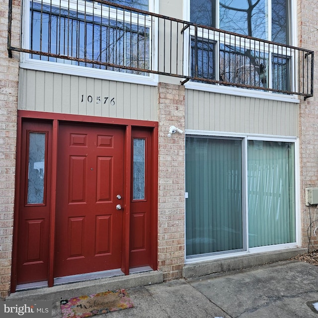 view of exterior entry with a balcony