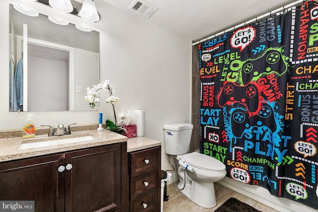 bathroom with vanity, toilet, and hardwood / wood-style floors