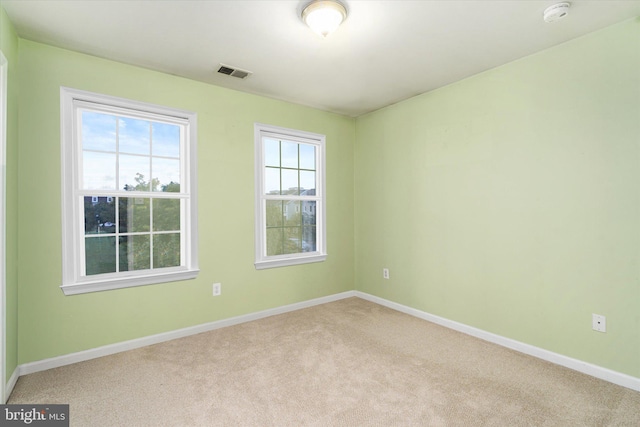 spare room featuring light colored carpet