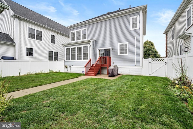 rear view of property featuring a lawn