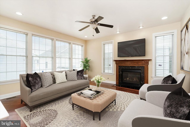 living room with ceiling fan, a premium fireplace, and hardwood / wood-style flooring