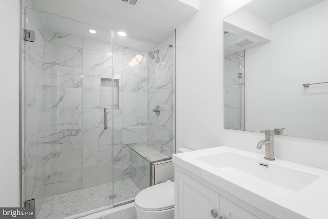 bathroom featuring toilet, walk in shower, and vanity