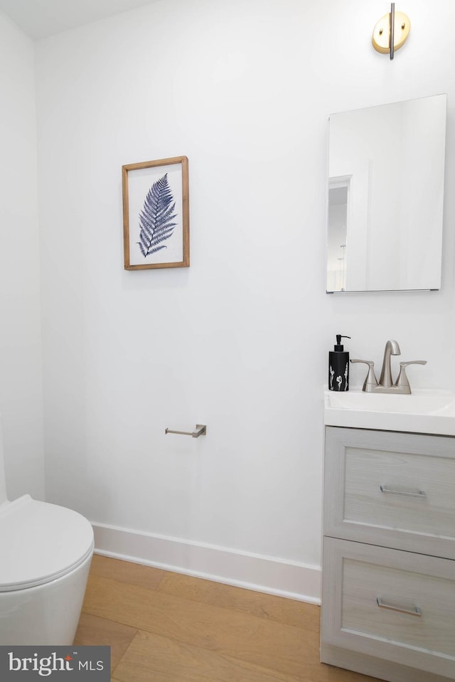 bathroom featuring toilet, vanity, and hardwood / wood-style floors