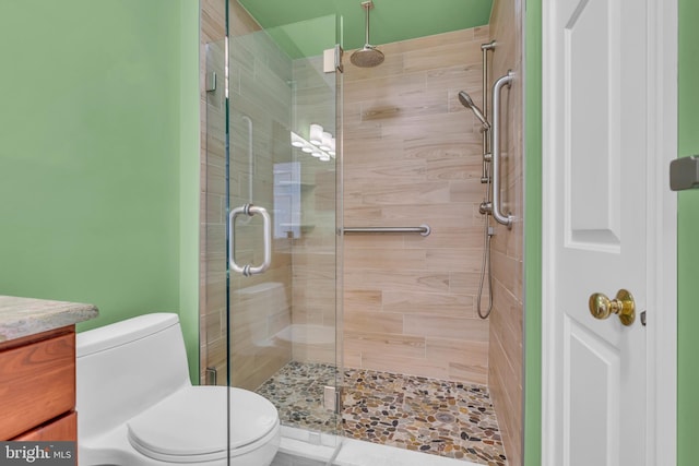 bathroom with toilet, walk in shower, and vanity