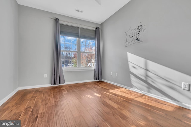 unfurnished room with wood-type flooring and lofted ceiling