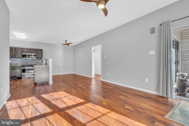 kitchen featuring ceiling fan, decorative backsplash, dark brown cabinetry, stainless steel appliances, and dark hardwood / wood-style floors