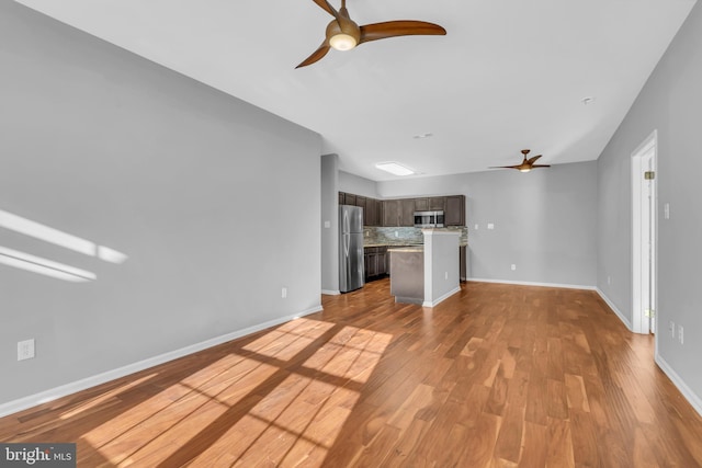 unfurnished living room with ceiling fan and light hardwood / wood-style flooring