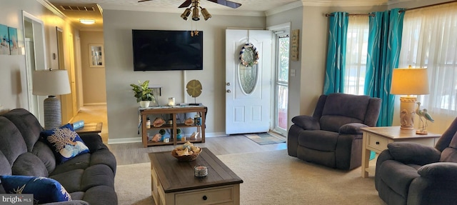 living room with ceiling fan, crown molding, and light hardwood / wood-style flooring