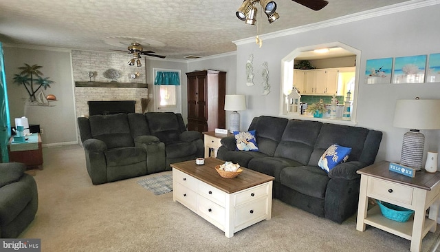 carpeted living room with a brick fireplace, a textured ceiling, ceiling fan, and ornamental molding