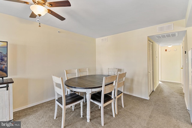 carpeted dining room with ceiling fan