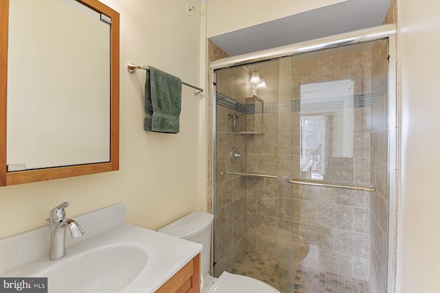 bathroom featuring walk in shower, vanity, and toilet