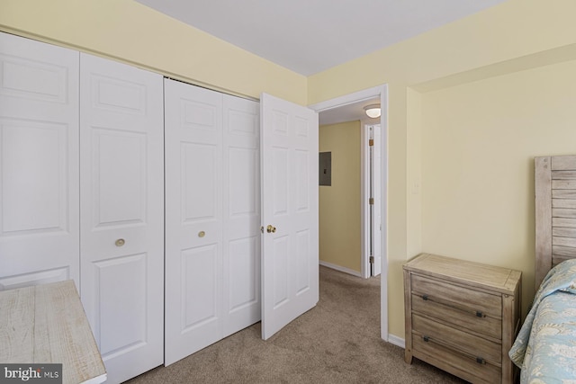 bedroom featuring a closet, light carpet, and electric panel