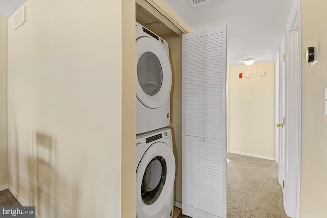 laundry room featuring stacked washer and clothes dryer and light colored carpet