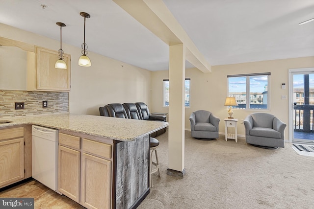 kitchen featuring white dishwasher, light brown cabinetry, and kitchen peninsula