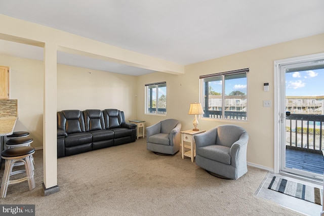 living room featuring beamed ceiling and carpet flooring