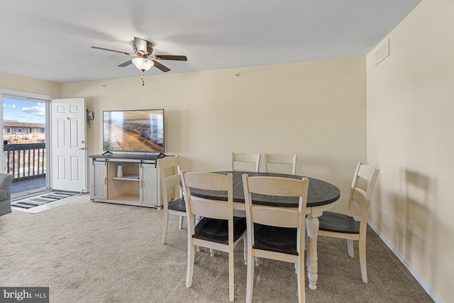 dining room with ceiling fan and carpet