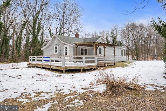 snow covered property with a wooden deck