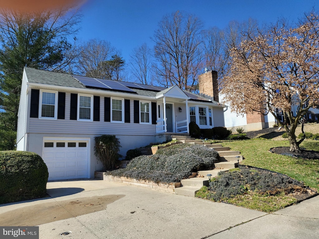 view of front of property featuring a garage and solar panels