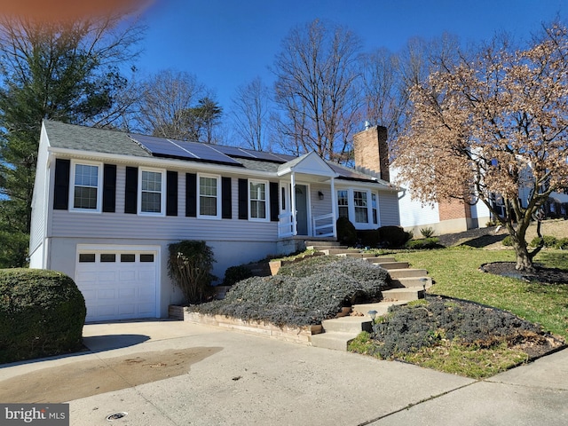 view of front of property featuring a garage and solar panels