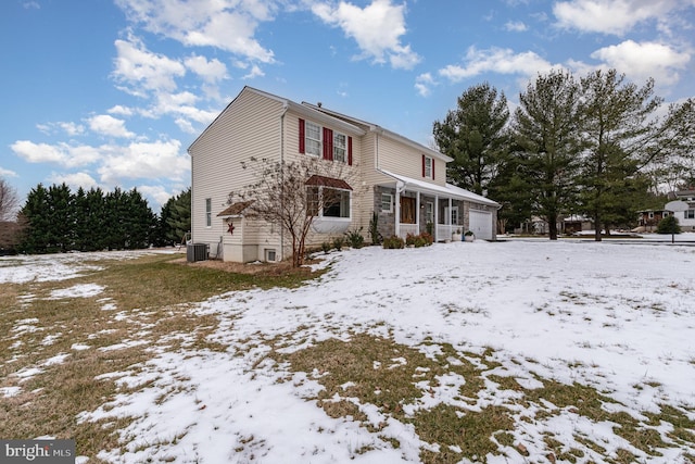 view of front of property featuring covered porch, a garage, and central air condition unit