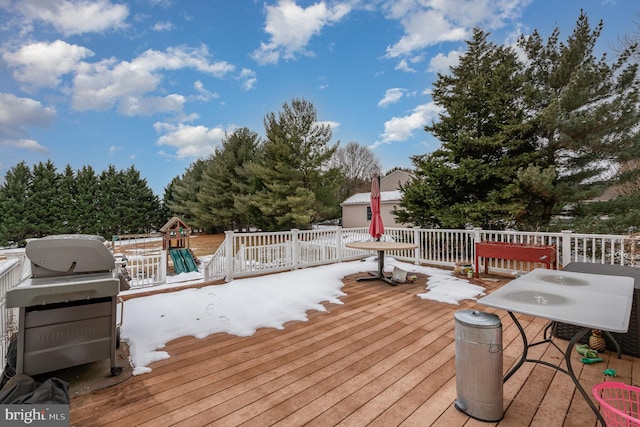 wooden deck with area for grilling and a playground