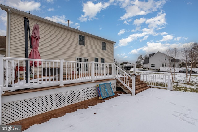 snow covered rear of property featuring a wooden deck