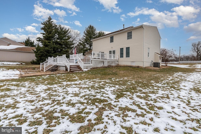 snow covered property with a deck and cooling unit