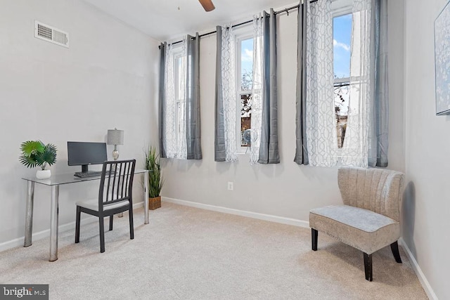 carpeted home office featuring ceiling fan