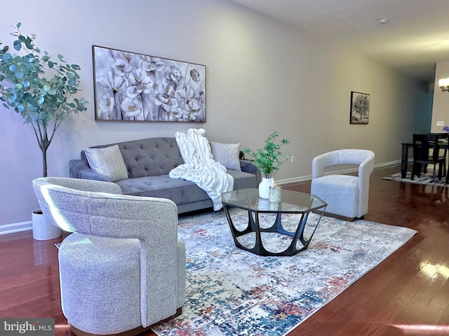 living room with a notable chandelier and dark hardwood / wood-style flooring