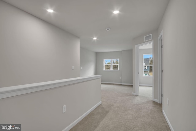 hallway featuring visible vents, baseboards, recessed lighting, an upstairs landing, and light colored carpet