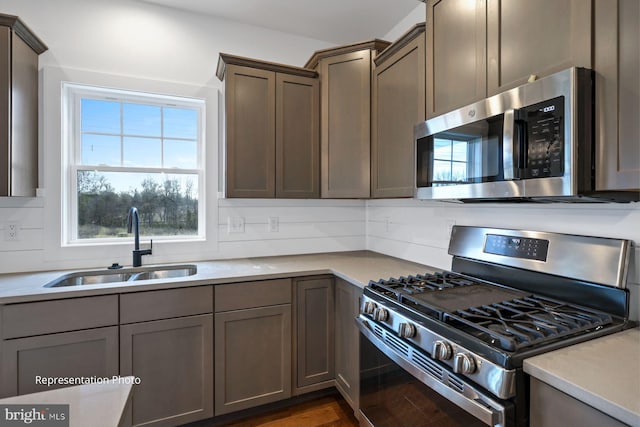 kitchen featuring stainless steel appliances, decorative backsplash, sink, and dark wood-type flooring