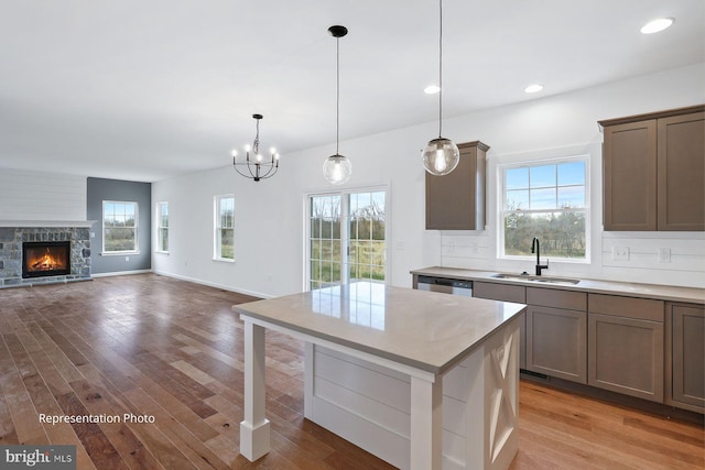 kitchen featuring tasteful backsplash, light countertops, light wood-style floors, and a sink