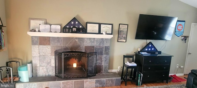 living room with a tiled fireplace and hardwood / wood-style floors