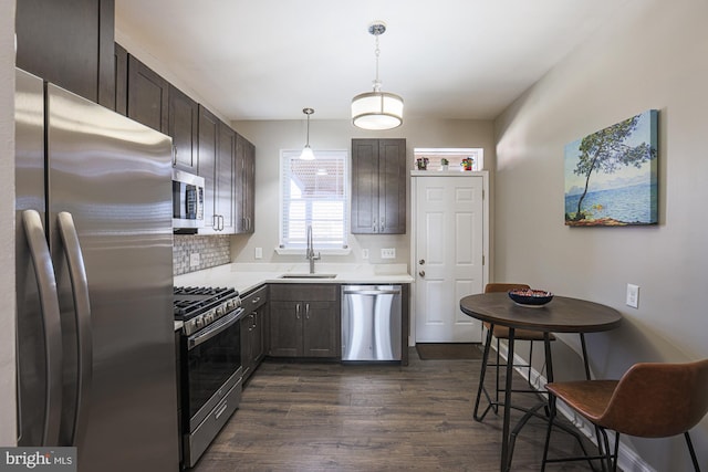 kitchen featuring dark brown cabinetry, stainless steel appliances, decorative light fixtures, and sink