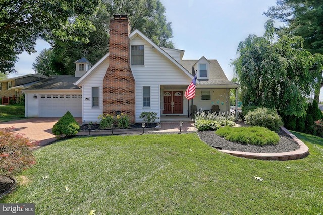 view of front of house with a front yard, a garage, and a porch