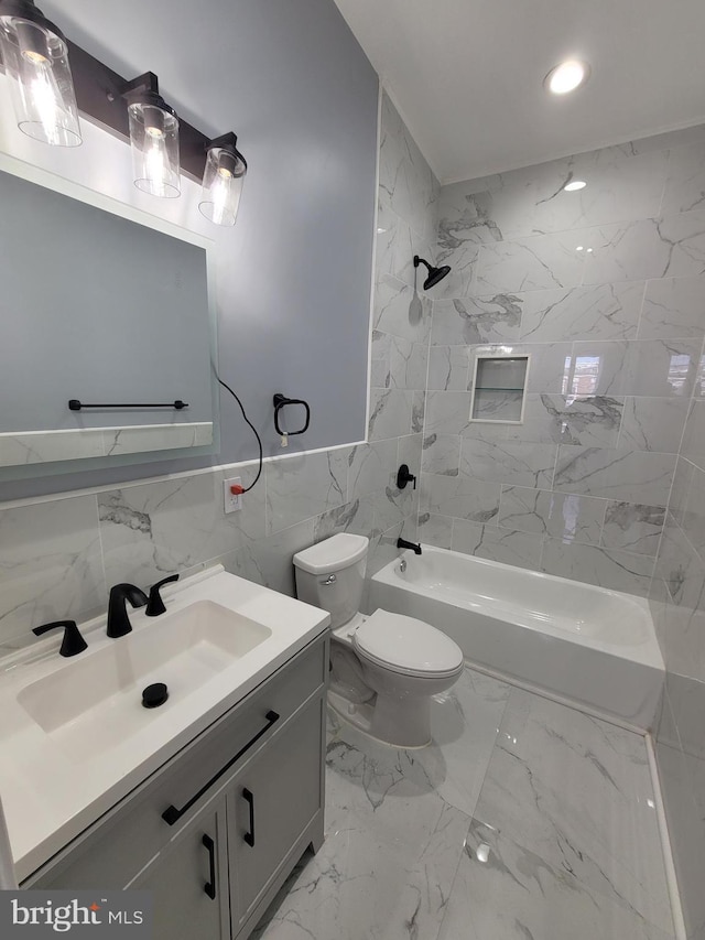 full bathroom featuring tile walls, toilet, vanity, and tiled shower / bath