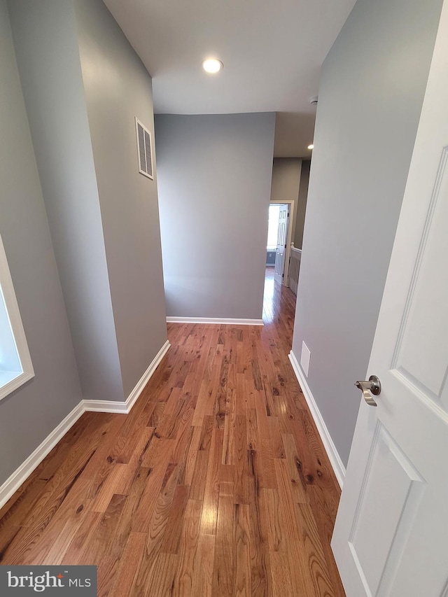 hallway with light hardwood / wood-style floors